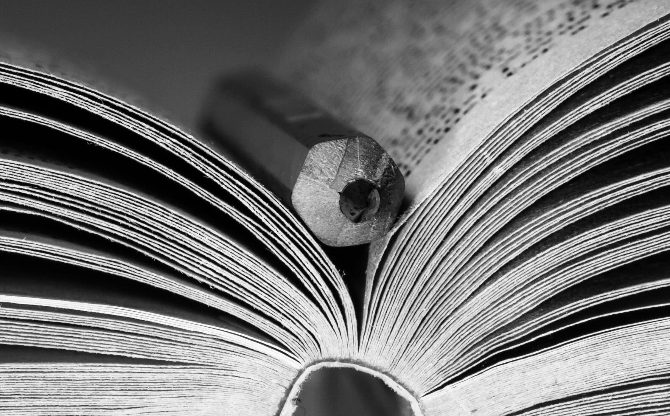 An open book with a pencil resting in the pages, photographed in the church