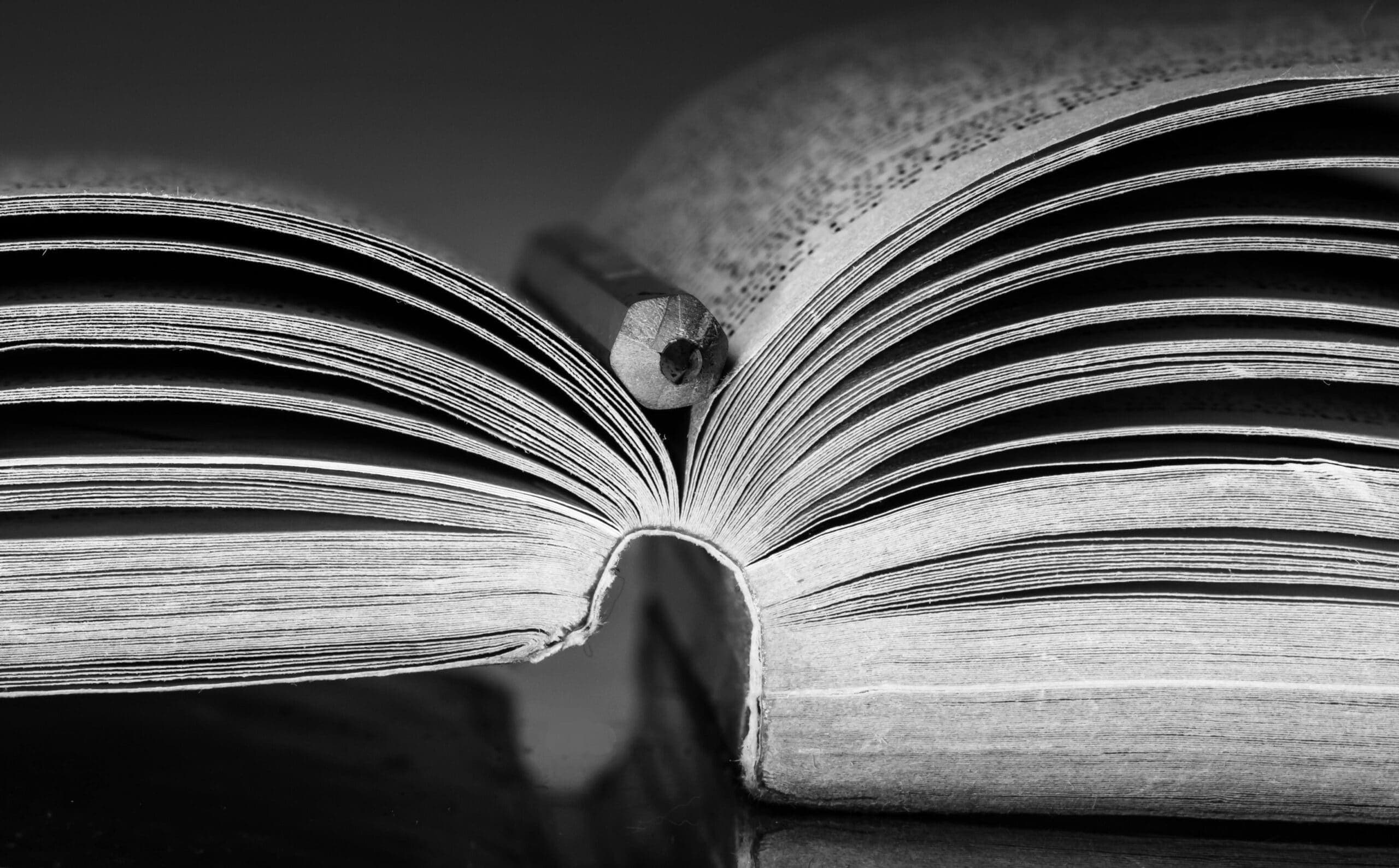 An open book with a pencil in the gutter, photographed in the church