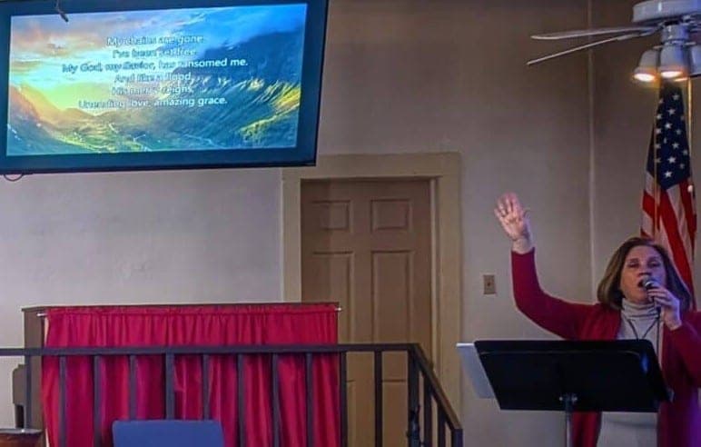 Laura Armstrong leading a song in the sanctuary